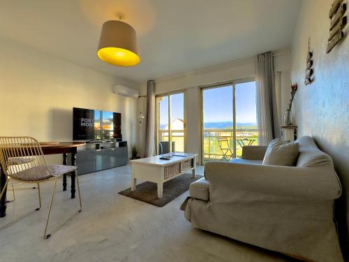 un salon avec un canapé et une table dans l'établissement L'Alexandra By SCLS Locations, à Cannes