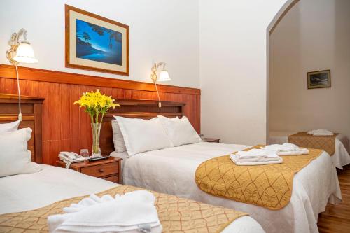 a hotel room with two beds with towels on them at Hotel Plaza in Punta Arenas