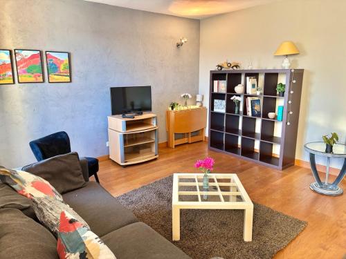 un salon avec un canapé et une télévision dans l'établissement Le Fouquet - T3 Duplex Panorama d'Exception sur la Mayenne, à Laval