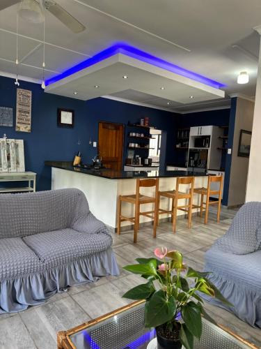a living room with a couch and a bar at BlueHive guesthouse in Port Edward
