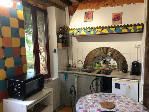 a small kitchen with a sink and a microwave at Studio les lodges de phanou in Prissac