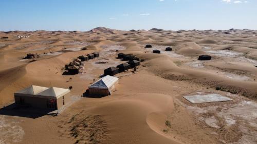 an aerial view of a desert with buildings at Erg Chigaga Torza Luxury Camp - Desert Glamping in El Gouera