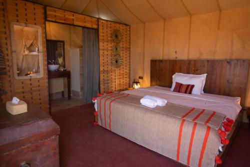 a bedroom with a large bed in a room at Erg Chigaga Torza Luxury Camp - Desert Glamping in El Gouera