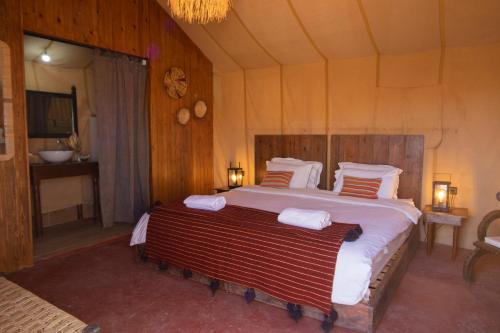 a bedroom with a large bed in a room at Erg Chigaga Torza Luxury Camp - Desert Glamping in El Gouera