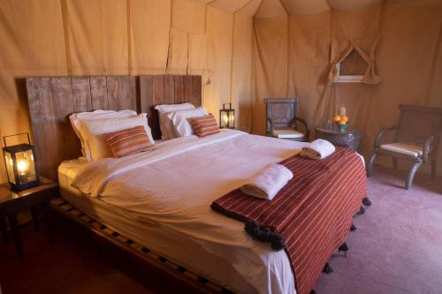 a bedroom with a large bed in a tent at Erg Chigaga Torza Luxury Camp - Desert Glamping in El Gouera