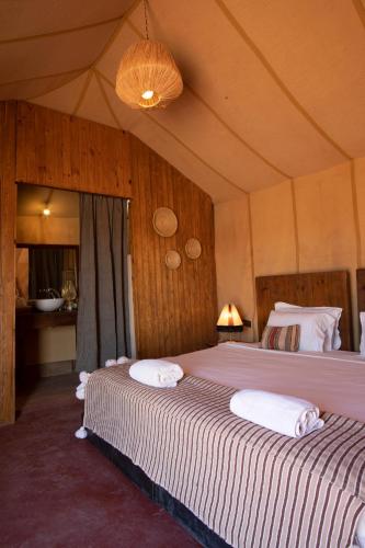 a bedroom with two beds in a tent at Erg Chigaga Torza Luxury Camp - Desert Glamping in El Gouera