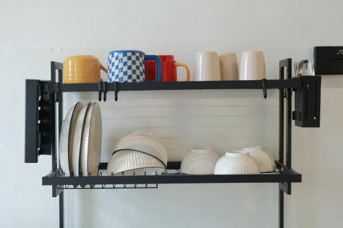 a black shelf with cups and vases on it at 嘿夏天 HeySummer-13pax l 200mJetty l Netflix l Games l Youtube in Mersing
