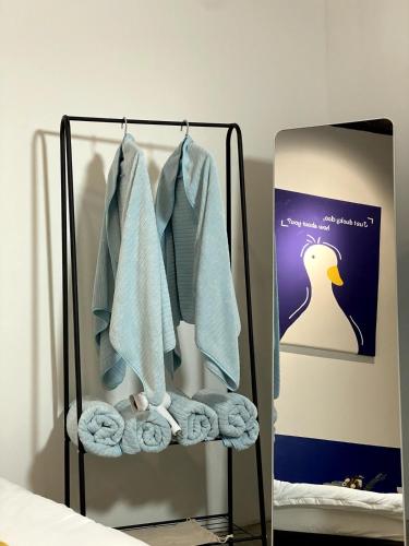 a towel rack with towels and a mirror at 嘿夏天 HeySummer-13pax l 200mJetty l Netflix l Games l Youtube in Mersing