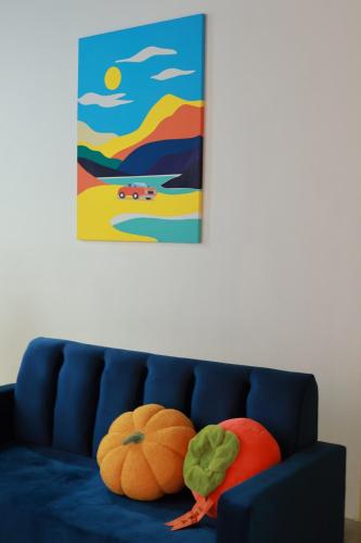 a blue couch with two pumpkins sitting on it at 嘿夏天 HeySummer-13pax l 200mJetty l Netflix l Games l Youtube in Mersing