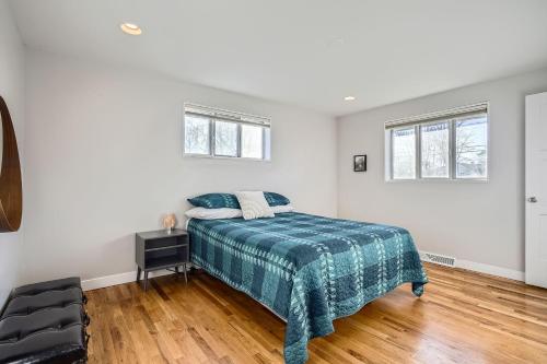 a white bedroom with a bed and two windows at Spacious Denver home in Denver