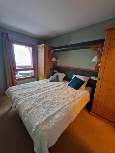 une chambre avec un grand lit et une fenêtre dans l'établissement Arc 1950 - Appartement 2 chambres - 6 personnes - 53m2-ski aux pieds - Les Sources de Marie, à Arc 1950