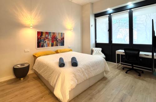 a bedroom with a bed with a desk and a desk at LUXURY SUITE Wifi AC SERVICIOS EN LA PUERTA in Madrid