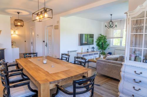 a kitchen and living room with a wooden table and chairs at Preciosa casa rural en Nava in Sienra