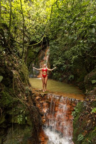 a woman standing on a waterfall in a stream at GreenOriental Resort in La Vega