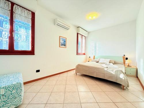 ein Schlafzimmer mit einem Bett und einem großen Fenster in der Unterkunft Appartamento La Cavaliera in San Vincenzo