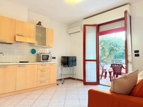 eine Küche mit einem Tisch und eine Tür zu einem Balkon in der Unterkunft Appartamento La Cavaliera in San Vincenzo