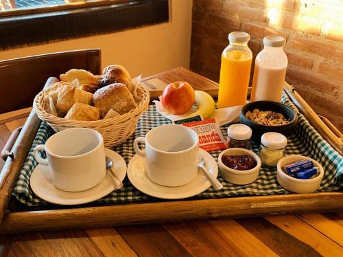 a tray with cups of coffee and pastries on a table at Villanto apart Solo Adultos in Mina Clavero