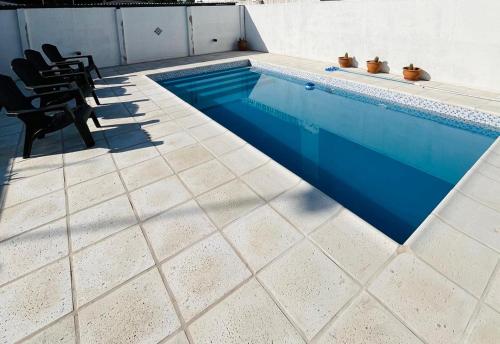 a swimming pool with blue water in a house at Villanto apart Solo Adultos in Mina Clavero