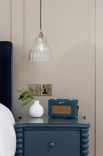 a blue dresser with a vase and a lamp at The Blue Pigeons Hotel and Restaurant in Worth