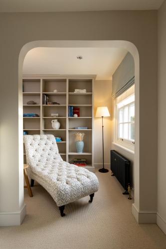a living room with a chair and a book shelf at The Blue Pigeons Hotel and Restaurant in Worth