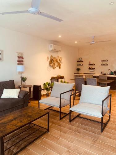 a living room with a couch and chairs and a table at Mar y Chelo Luxury Aparments in Isla Mujeres