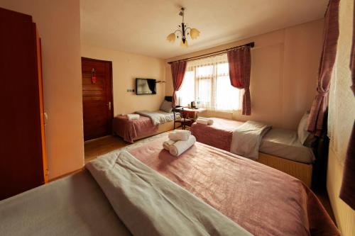 a bedroom with two beds and a window at Abant Barış Pansiyon in Dereceören