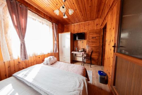 a bedroom with a bed and a window and a desk at Abant Barış Pansiyon in Dereceören