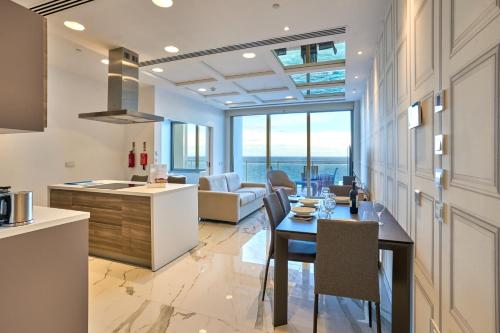 a kitchen and living room with a table and chairs at Coastal One Bedroom Retreat with direct Breathtaking Sea Views in Sliema