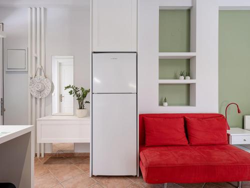 a kitchen with a red couch and a white refrigerator at Elena Seafront Luxury Apartments in Almirida