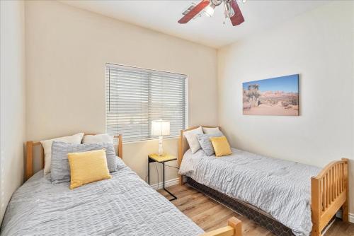 a bedroom with two beds and a window at Henderson Hacienda, 5br free heated pool-spa, 15 min to Strip in Henderson