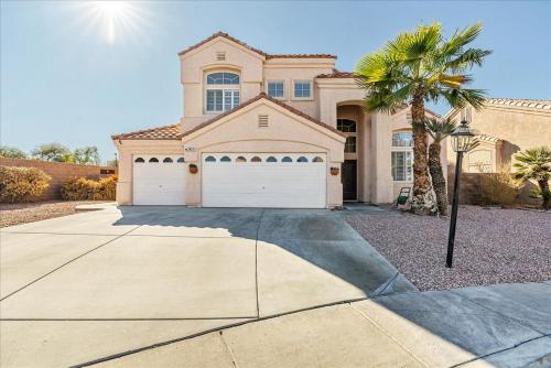 a house with a palm tree in front of a driveway at Henderson Hacienda, 5br free heated pool-spa, 15 min to Strip in Henderson