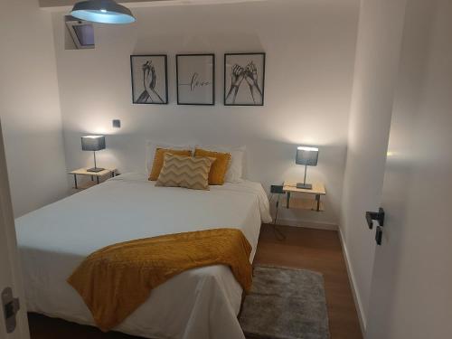 a bedroom with a white bed and two lamps at Kings B&B Eiras in Caniço