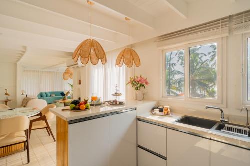 a white kitchen with a sink and a table at ELIVAAS House of Neptune - 3 BHK Cottage with Terrace & Gazebo on the Beach in Morjim