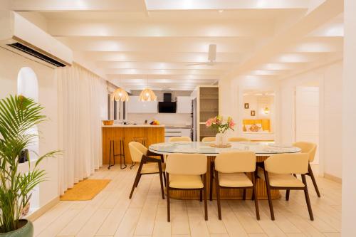 a kitchen and dining room with a table and chairs at ELIVAAS House of Neptune - 3 BHK Cottage with Terrace & Gazebo on the Beach in Morjim