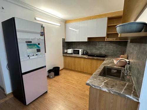 eine Küche mit einem schwarzen und weißen Kühlschrank in der Unterkunft Mary House in Buôn Ea Trum