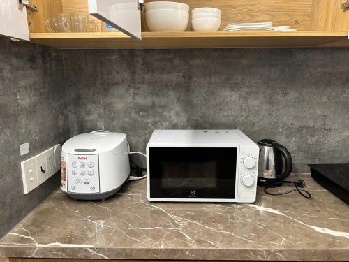eine Mikrowelle auf einer Theke in einer Küche in der Unterkunft Mary House in Buôn Ea Trum