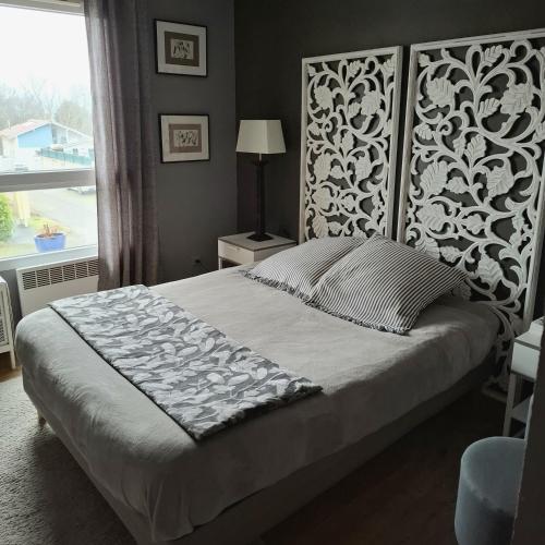 une chambre avec un lit avec une tête de lit et une fenêtre dans l'établissement Chambre et jardin, à Bayonne