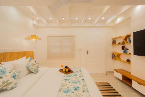 a bedroom with a bed with a bowl of fruit on it at ELIVAAS House of Neptune - 3 BHK Cottage with Terrace & Gazebo on the Beach in Morjim