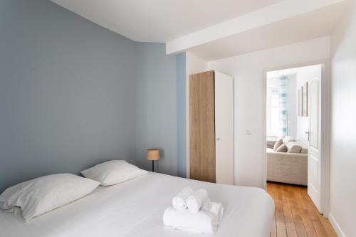 - une chambre avec un lit blanc et 2 serviettes dans l'établissement L'Archipel - Dans l'Intra Muros, à Saint-Malo