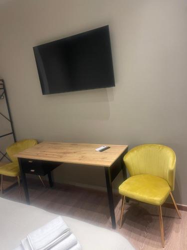 a table with two chairs and a television on a wall at Stazione Tiburtina Roma in Rome