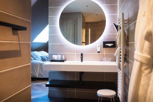 a bathroom with a sink and a mirror at LA CHENEAUDIÈRE - Hôtel Spa - Relais & Châteaux - Restaurant étoilé in Colroy-la-Roche