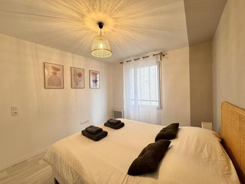 a bedroom with a bed with two pillows on it at L'Azur - Parking - Balcon - Circuit 24h - 4 pers in Le Mans