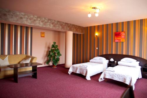 a hotel room with two beds and a couch at Hotel Horyzont in Rzeszów