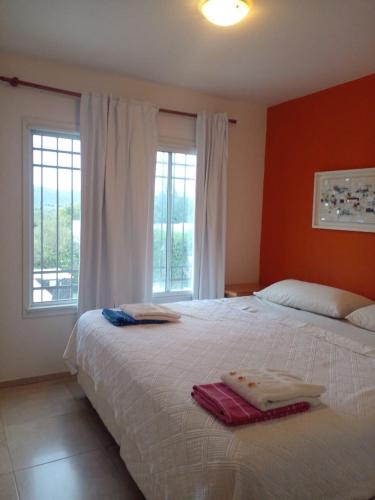 a bedroom with a large bed with two towels on it at Casa en Lomas del Rey - Mayu Sumaj in San Antonio de Arredondo
