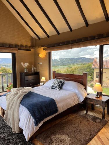 a bedroom with a large bed with a large window at Hotel, Glampings y Cabaña Magic Bungalow in Villa de Leyva
