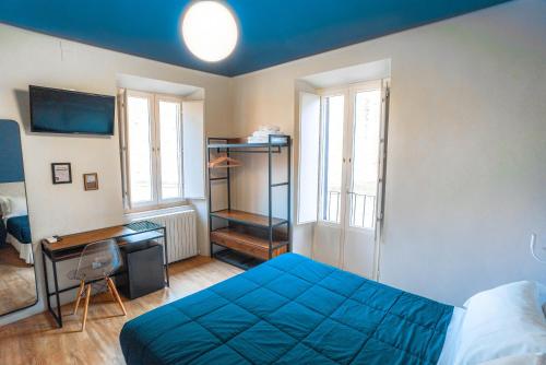 a bedroom with a blue bed and a desk at I Mecenati in Macerata