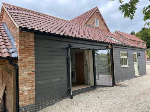 a large grey shed with a large sliding door at Rural Retreat, 1 bed, sleeps 2 near Bleasby in Bleasby