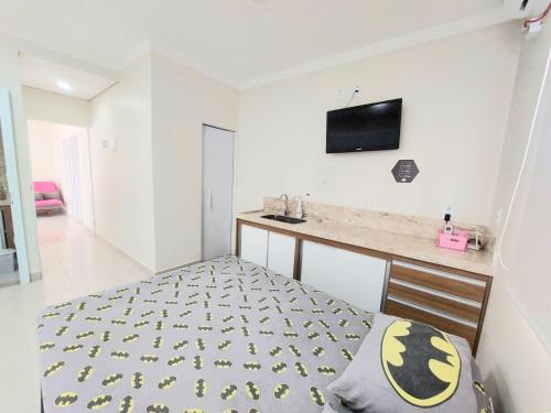 a bedroom with a bed and a tv on the wall at Aconchego perfeito em São Pedro SP in São Pedro