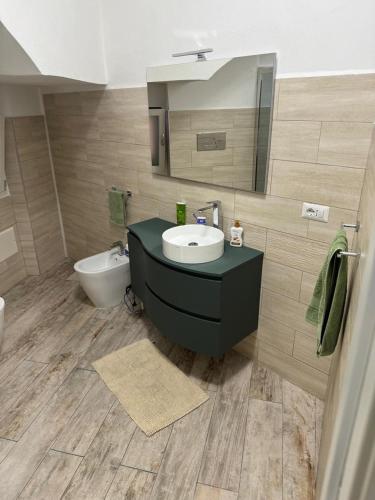 a bathroom with a sink and a toilet and a mirror at casa Palau in Palau
