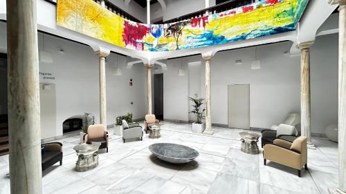 a large lobby with a large painting on the ceiling at El Ladrón De Agua Palacete in Granada
